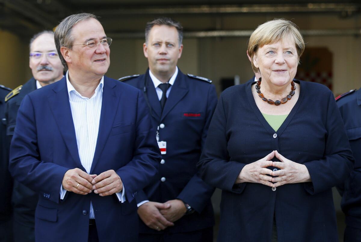 German Chancellor Angela Merkel and North Rhine-Westphalia's State Premier, chairman of the Christian Democratic Union party and candidate for Chancellery Armin Laschet, left, visit the fire station in Schalksmuehle, Germany, Sunday Sept. 5, 2021. (Thilo Schmuelgen/Pool via AP)