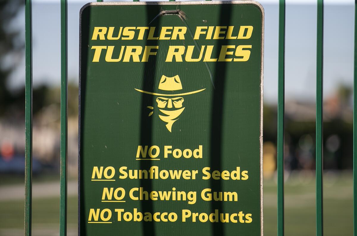 A sign posted at the Golden West College football field features Rustler Sam, the school's mascot.
