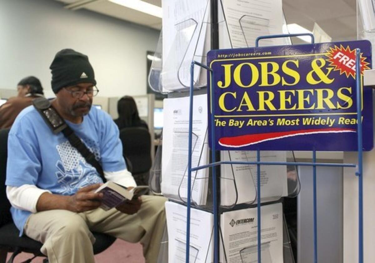 A job seeker waits to use a phone at a career center in Richmond, Calif.