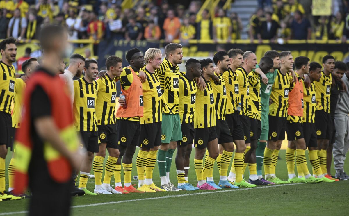 Dortmund's players stand together after the final whistle of the German Bundesliga soccer match between Borussia Dortmund and Bayer Leverkusen in Dortmund, Germany, Saturday, Aug. 6, 2022. (Bernd Thissen/dpa via AP)