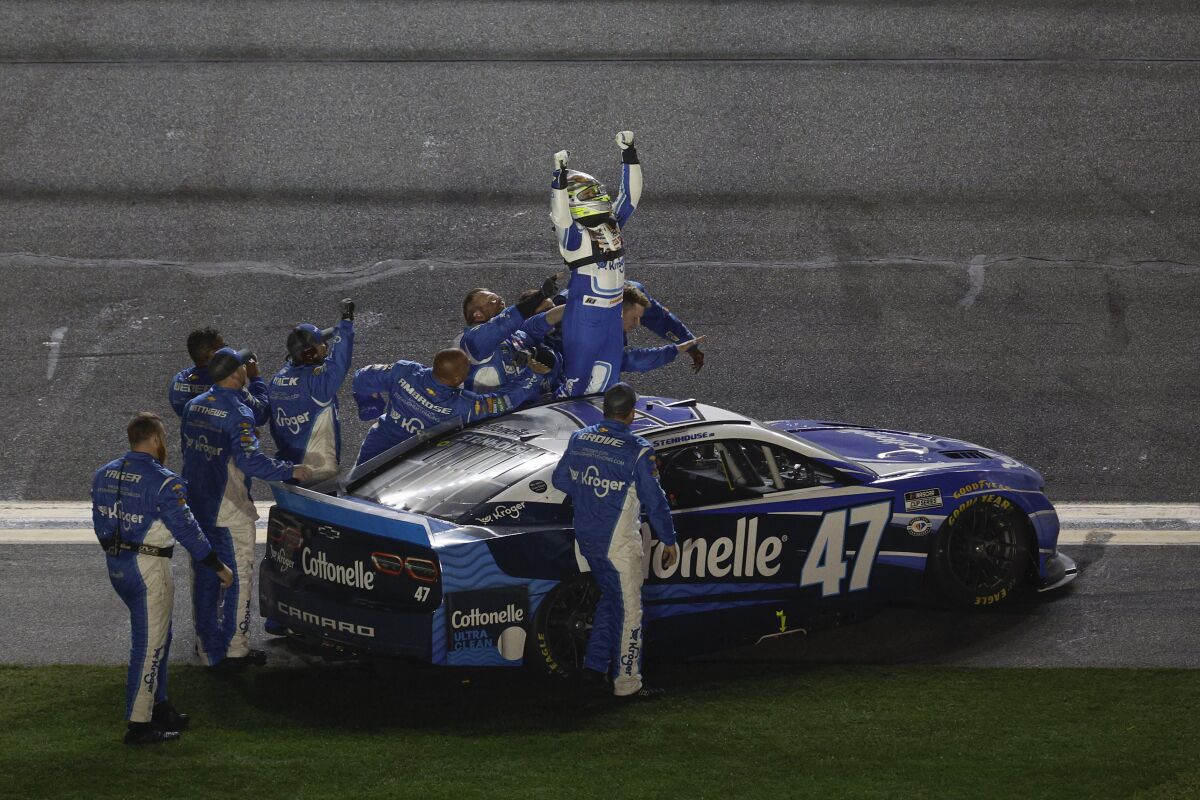 Ricky Stenhouse Jr. celebrates with his crew on the track after winning the Daytona 500.