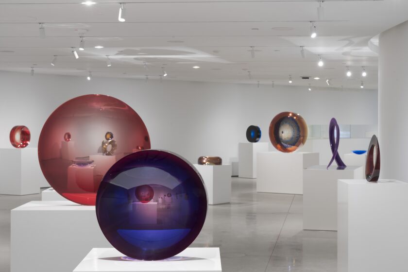 An installation view of cast plastic sculptures by Fred Eversley that gather light and focus refractions