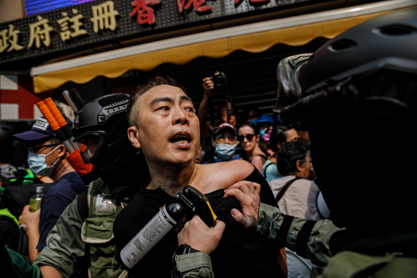 Hong Kong police officers in riot gear arrest a man they try to disperse demonstrators, gathering in defiance of the upcoming China's national day, in Causeway Bay area of Hong Kong, on Sept. 29, 2019.