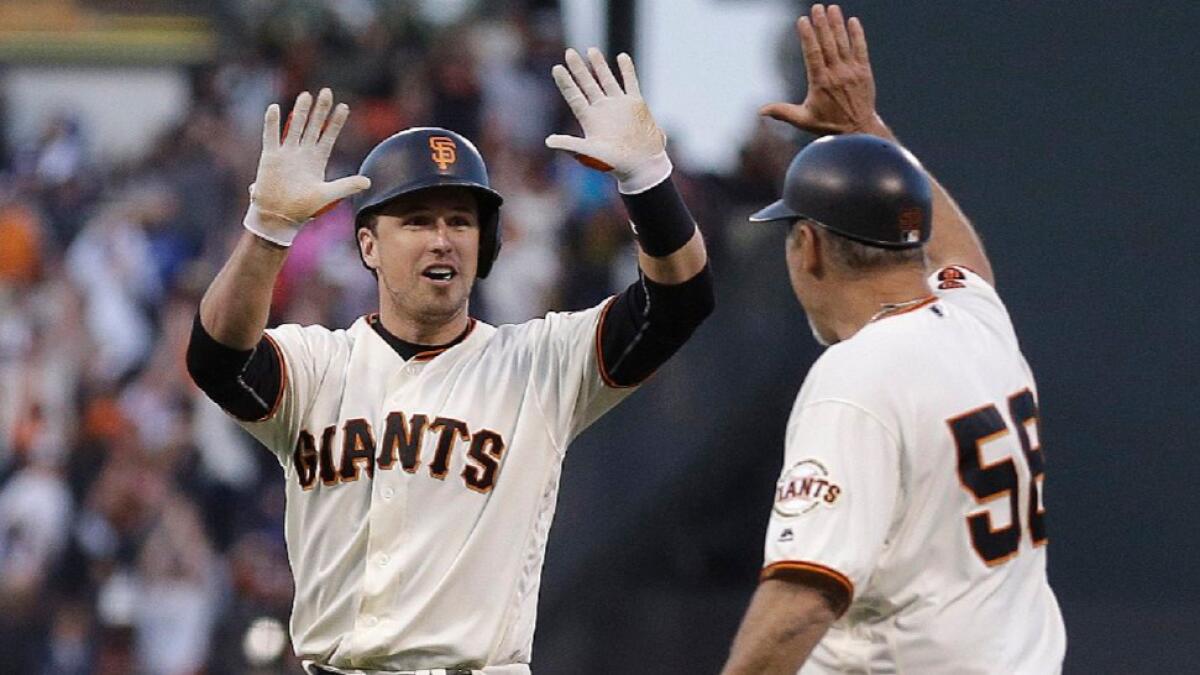 Giants catcher Buster Posey celebrates with first base coach Bill Hayes after hitting a walk-off single against the Dodgers on June 11.