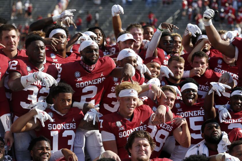 Quarterback Spencer Rattler, bottom middle in headband, and his Oklahoma teammates pose after beating Texas on Oct. 10, 2020.
