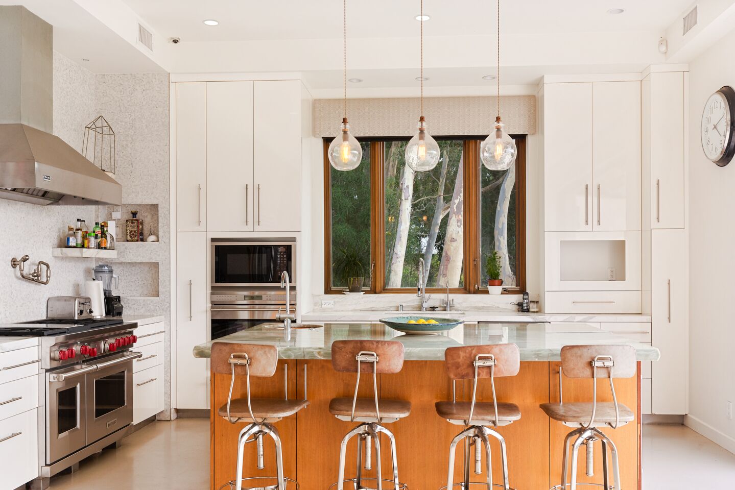 The kitchen has a large with seating for four, tall cabinets and large window over the sink.