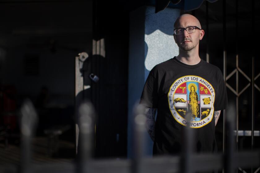 LYNWOOD, CA - NOVEMBER 25, 2020: Author Ryan Gattis inside the rod iron fencing at Mariscos El Paisa restaurant which is depicted in his new book "The System" on November 25, 2020 in Lynwood, California.(Gina Ferazzi / Los Angeles Times)