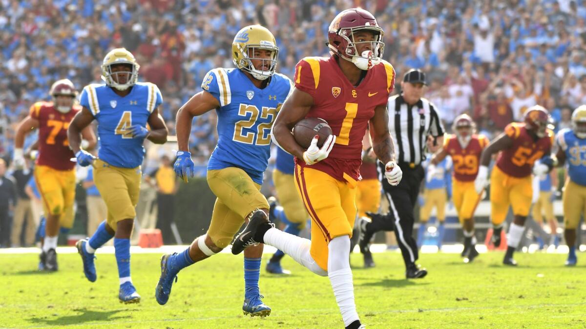 USC receiver Velus Jones Jr. sprints to the end zone for a touchdown as UCLA defensive back Nate Meadors gives chase at the Rose Bowl.