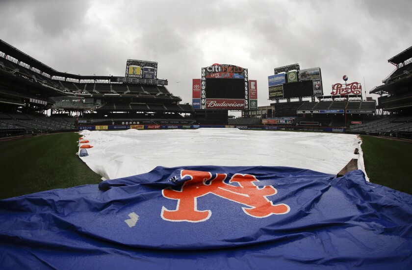 A tarp covers the field at Citi Field as a steady rain falls Friday in New York.