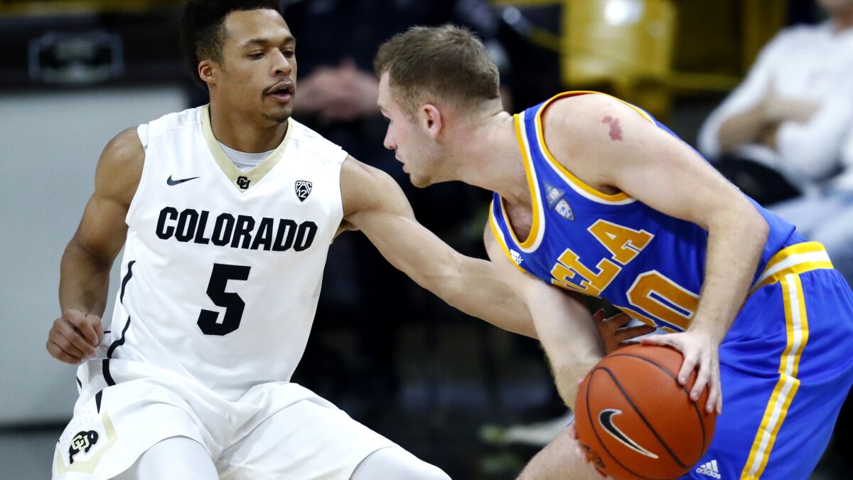 UCLA guard Bryce Alford protects the basketball as Colorado guard Deleon Brown takes a swipe at it during the second half Thursday.