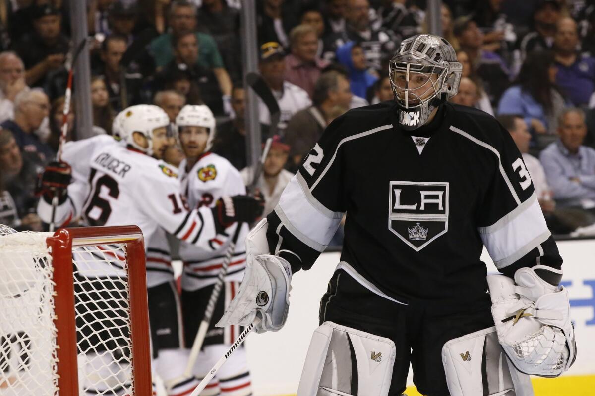 Kings goaltender Jonathan Quick skates away from the goal as Blackhawks players celebrate a score by Ben Smith in the second period.
