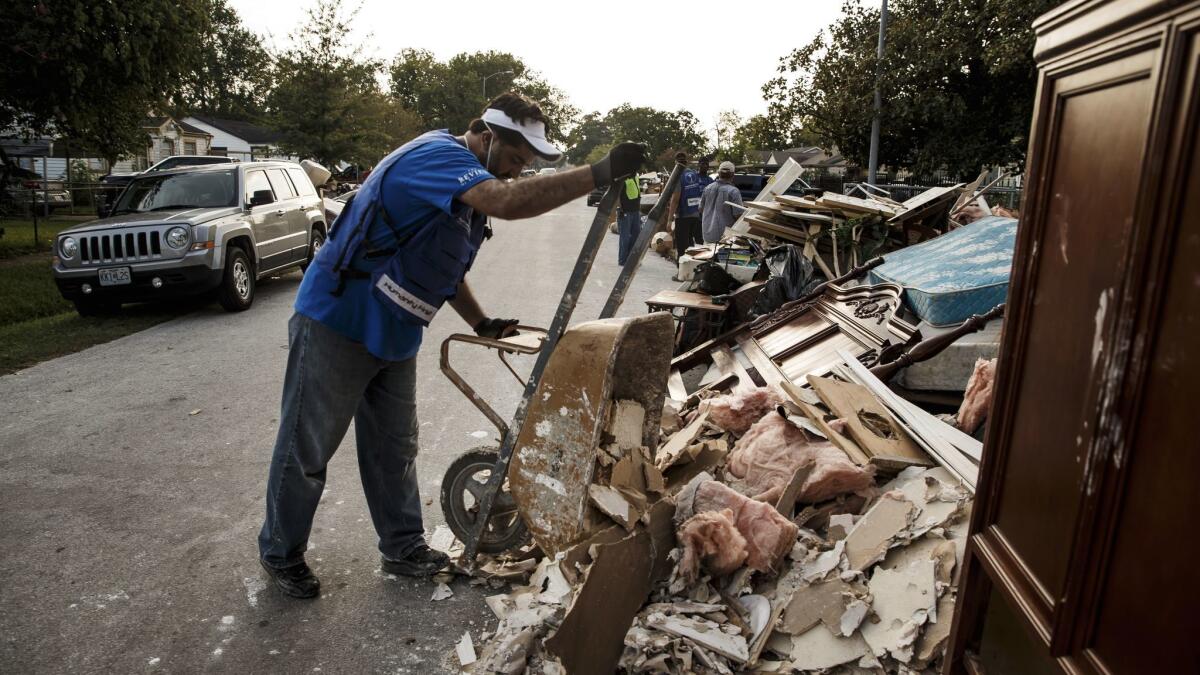 Bilal Rana, national president of the Ahmadiyya Muslim Youth Assn., help residents of Houston's Kashmere Gardens throw out moldy debris.