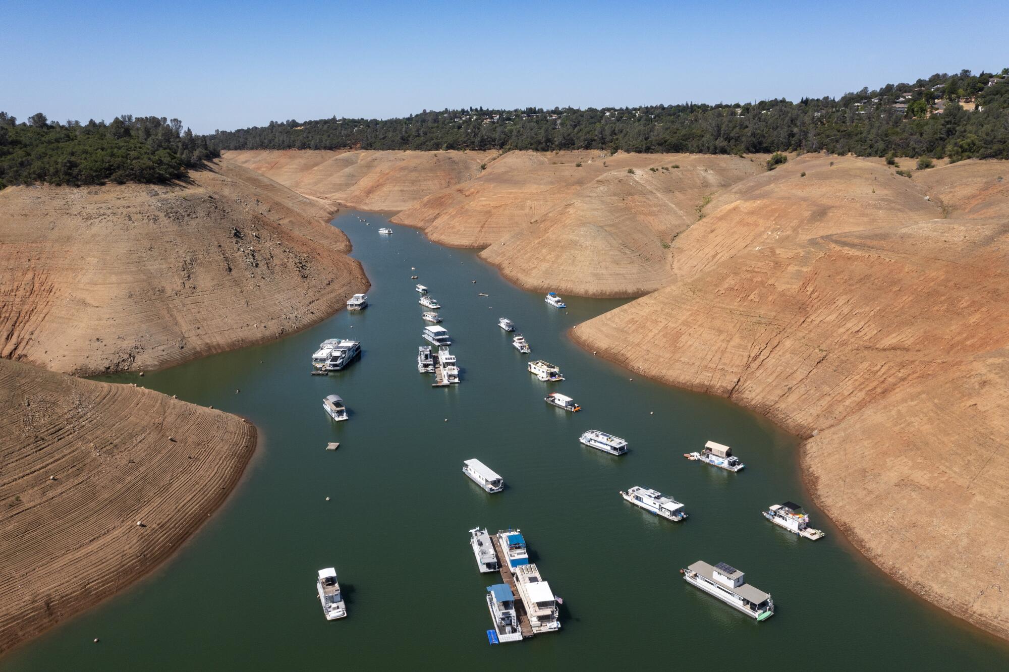 Boats are moored in a shrinking arm of Lake Oroville.