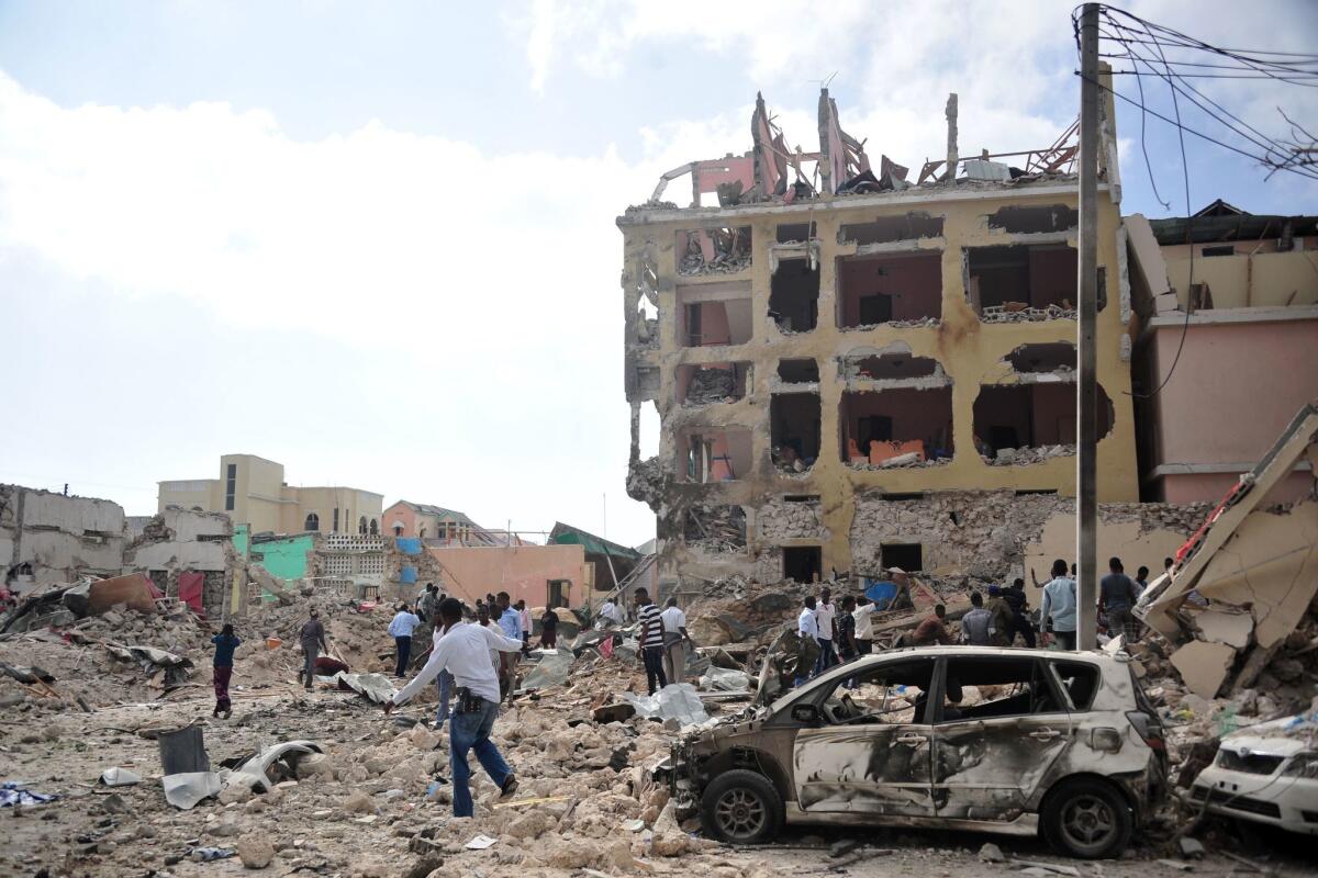 People walk in the rubble outside a Mogadishu, Somalia, hotel following an attack by extremists on Jan. 25.