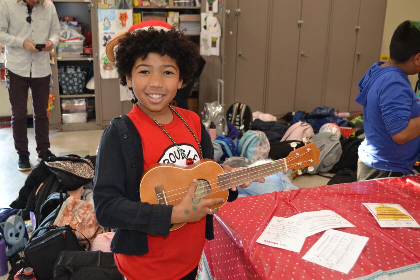 During a Christmas party at Valley Elementary School, Morelle Austin learns to play the ukulele.