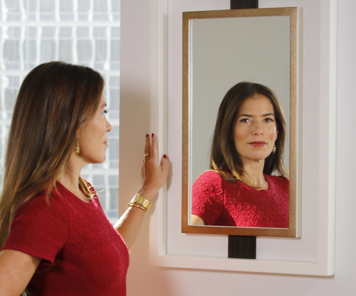 A woman's reflection is seen in a mirror 