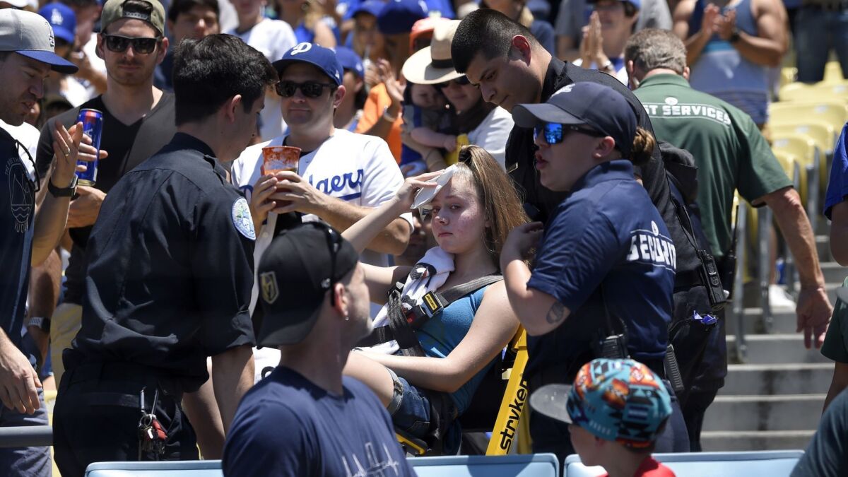A young fan is carted away after being hit with a foul ball off the bat of Cody Bellinger during the first inning of Sunday's game against the Colorado Rockies at Dodger Stadium.