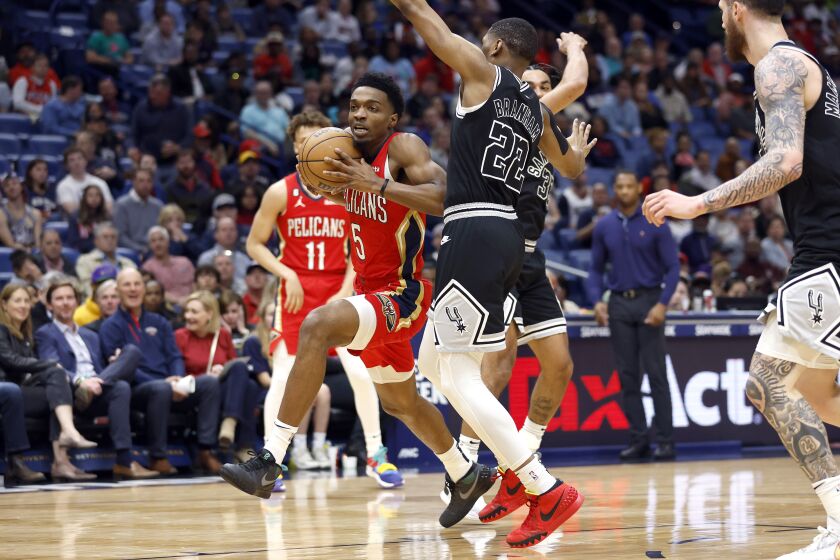 Herbert Jones (5) de los Pelicans de Nueva Orleáns se desplaza frente a Malaki Branham (22) de los Spurs de San Antonio, el martes 21 de marzo de 2023, en Nueva Orleáns. (AP Foto/Tyler Kaufman)
