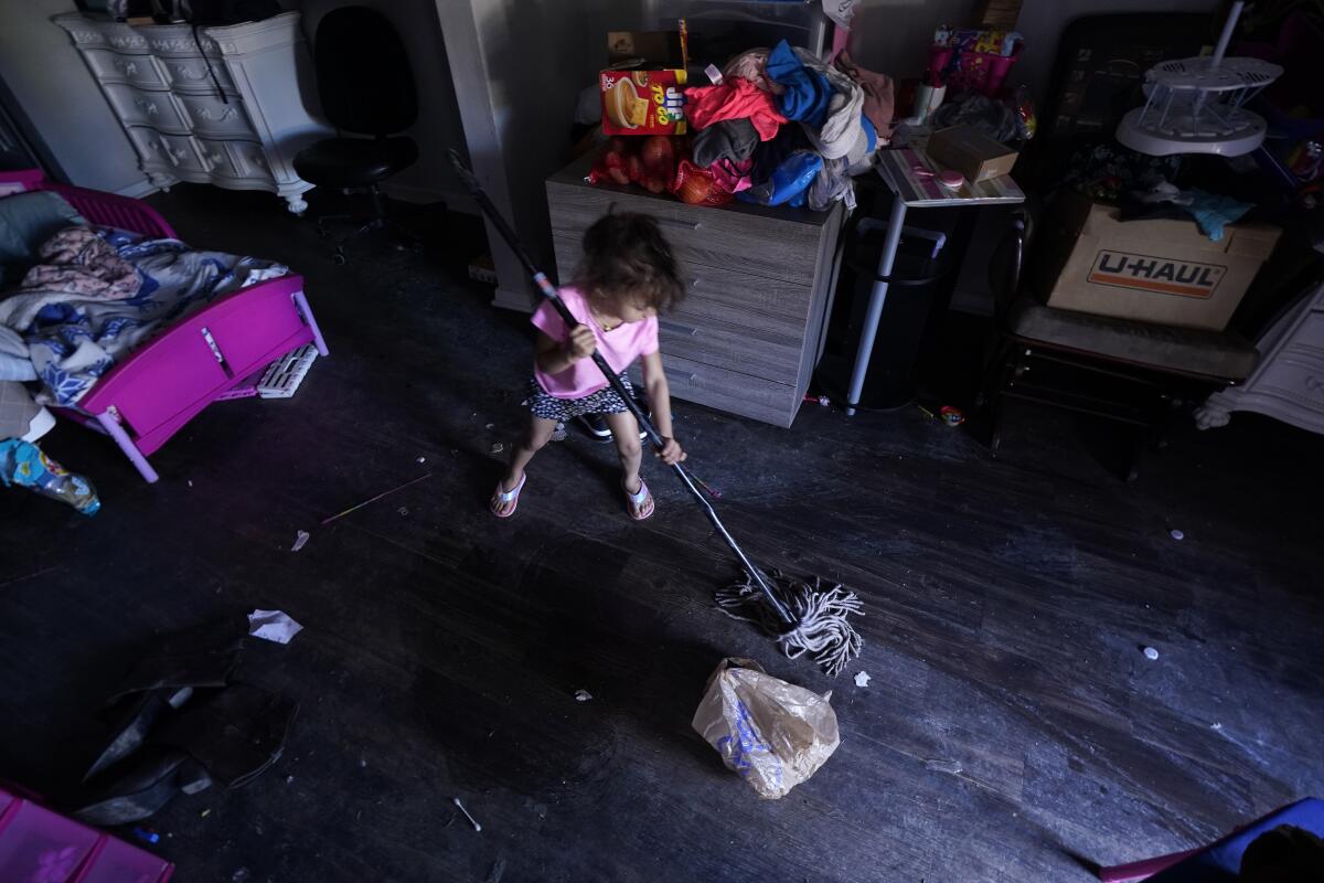 Raella Mills, 3, plays mop-up at her home in Dallas. 
