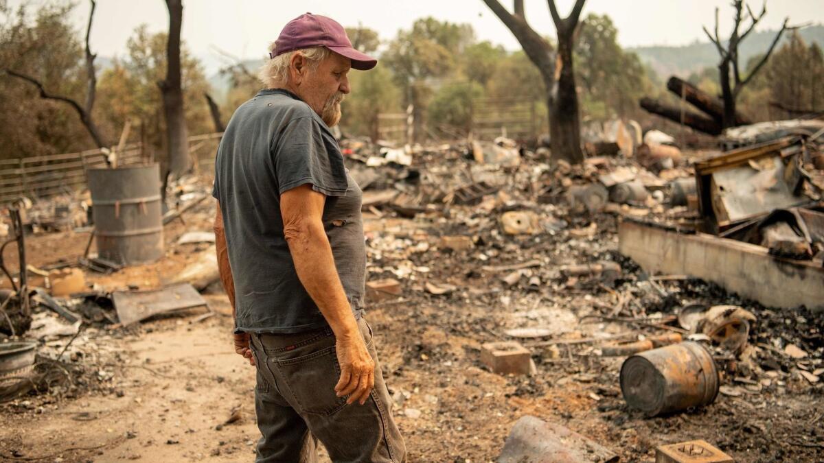 Resident Arnold Lasker looks over the burned out remains of his girlfriend's house in Spring Valley, near Clearlake Oaks.