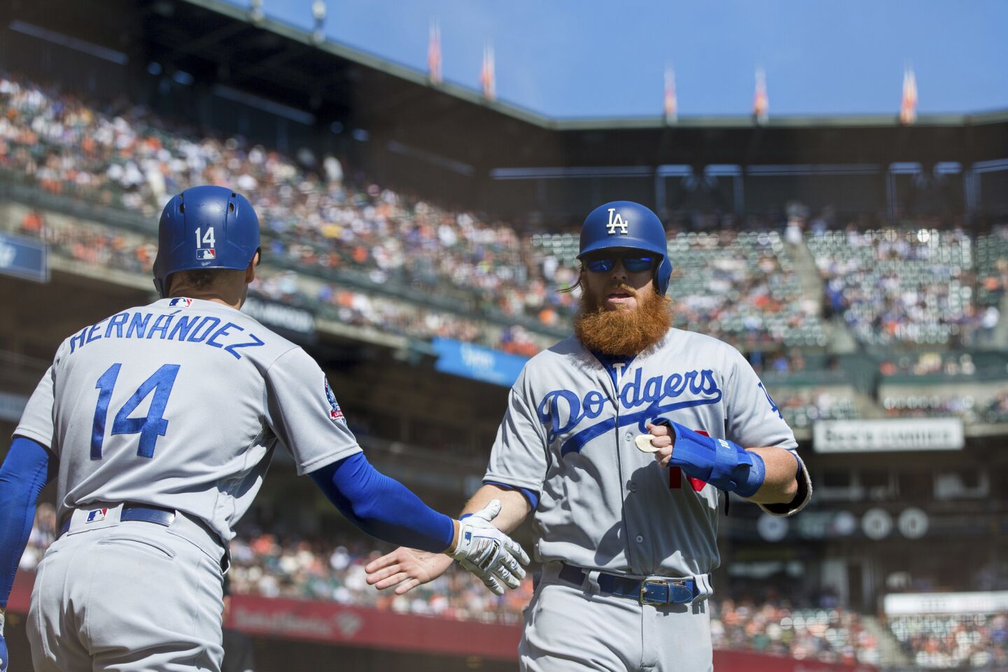 Los Angeles Dodgers Justin Turner, right, celebrates with Enrique Hernandez after scoring a run against the San Francisco Giants in the third inning of a baseball game in San Francisco, Sunday, Sept. 30, 2018. (AP Photo/John Hefti)