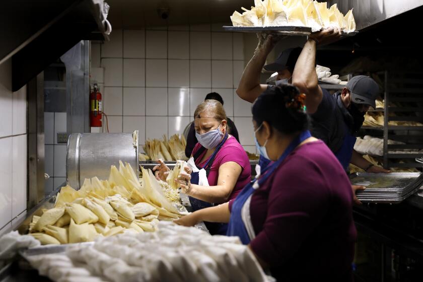 LOS ANGELES-CA-DECEMBER 4, 2020: Workers including Maria Franco, center, and Lucy Torres, foreground, make tamales at Tamales Liliana's in Los Angeles on Friday, December 4, 2020. (Christina House / Los Angeles Times)