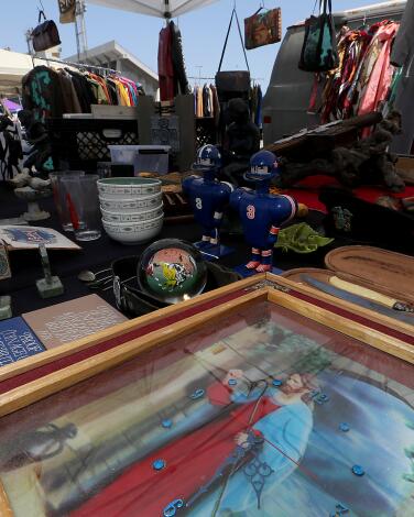 A woman shops for antiques at at an outdoor swap meet