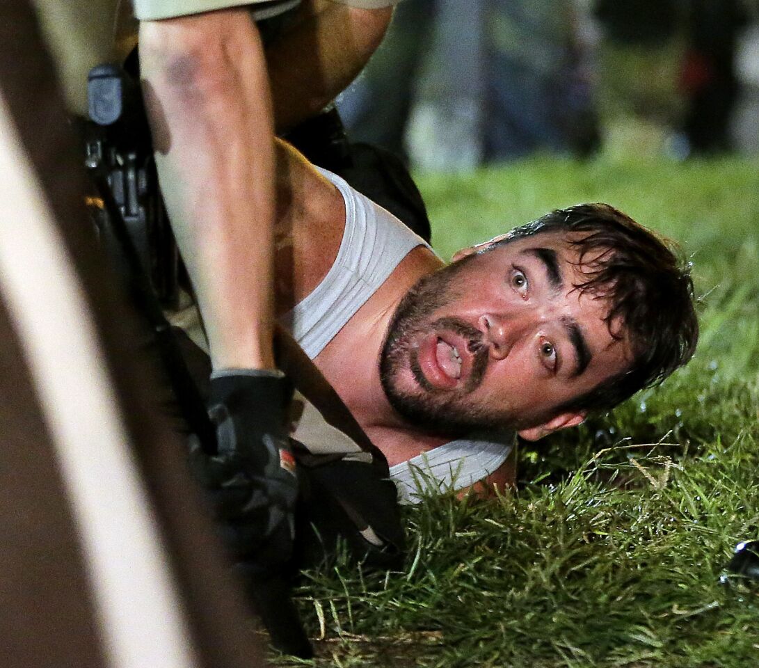 A man is detained by police during a protest Monday in Ferguson, Mo.