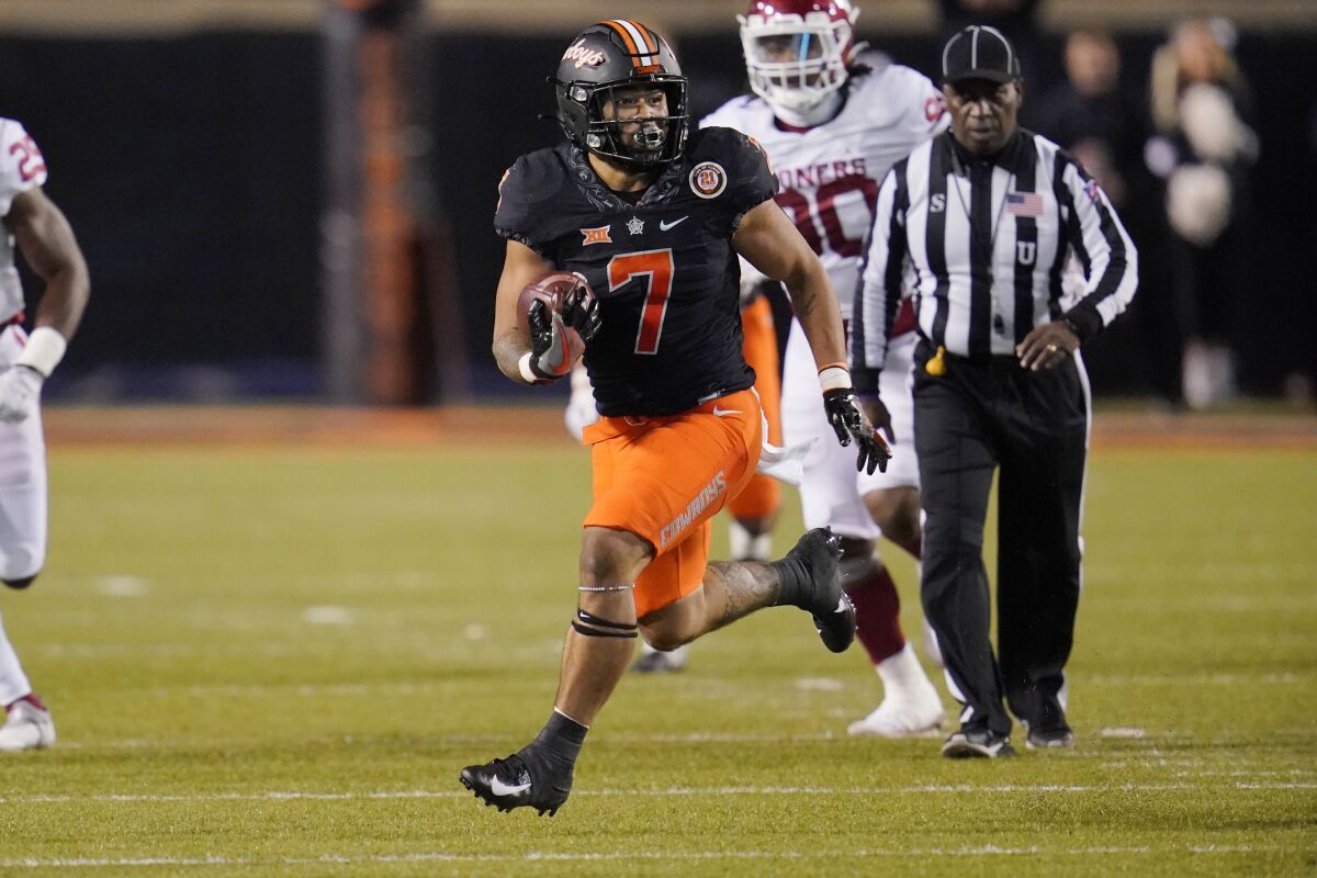 Oklahoma State running back Jaylen Warren (7) carries during the second half of the team's NCAA college football game against Oklahoma, Saturday, Nov. 27, 2021, in Stillwater, Okla. (AP Photo/Sue Ogrocki)