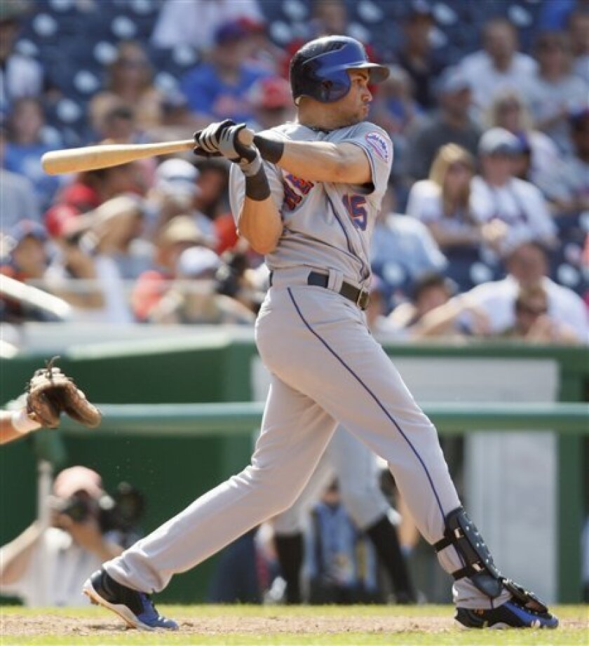 New York Mets' Carlos Beltran follows through on an RBI-double during the ninth inning of a baseball game against the Washington Nationals in Washington, Sunday, June 7, 2009. The Mets won 7-0. (AP Photo/Charles Dharapak)