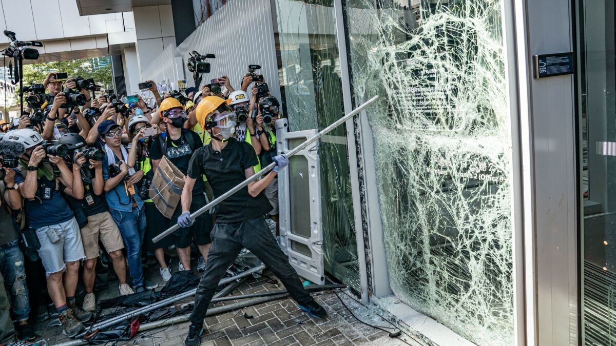 Protesters smash glass doors and windows of the Legislative Council complex in Hong Kong on July 1, 2019.