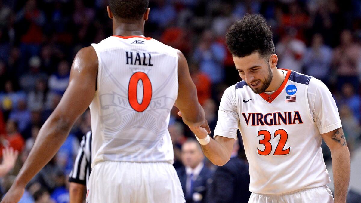 Virginia guard London Perrantes (32) and teammate Devon Hall celebrate during a win over Butler.