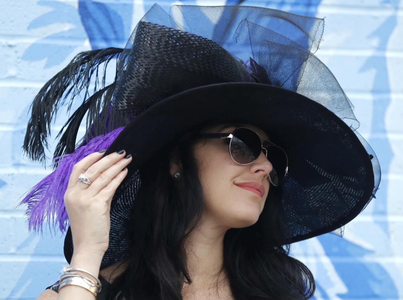 A woman shows off her hat before the 144th running of the Kentucky Derby.