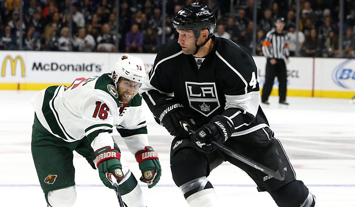 Kings defenseman Robyn Regehr looks to pass the puck as he pressure by Wild left wing Jason Zucker during a game Oct. 19.