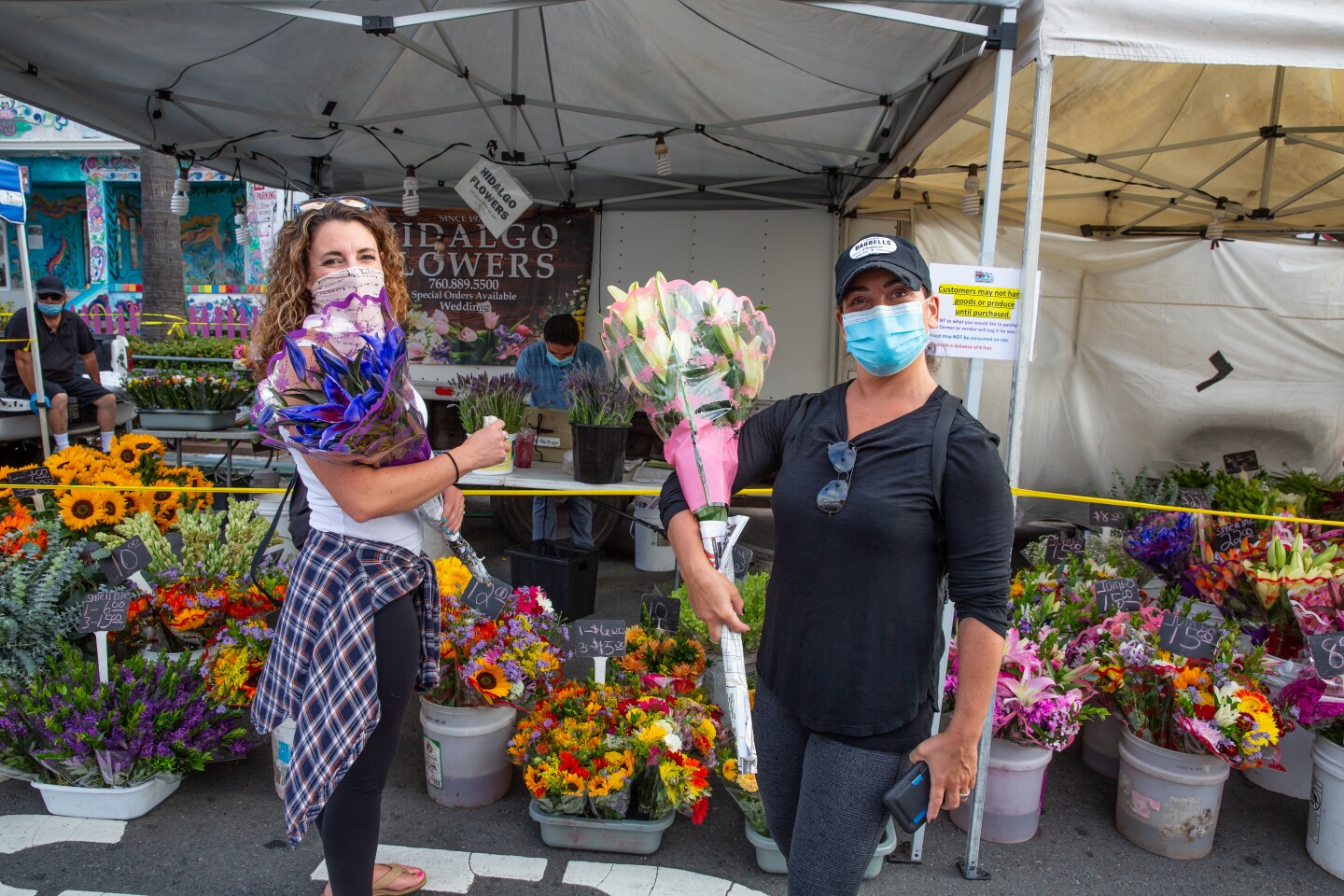 Lori Meagher (left) and Jordanna Kasander shop at Hidalgo Flowers at the Ocean Beach Farmers Market.