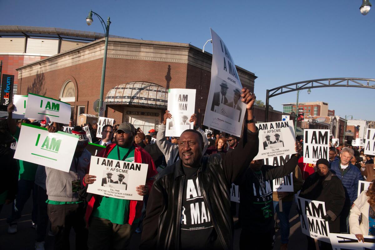 People carrying signs with the "I Am A Man" slogan from the 1968 sanitation workers strike gather for a rally on Beale Street in Memphis, Tenn., part of the observance of the 50th anniversary of the assassination of Martin Luther King Jr.