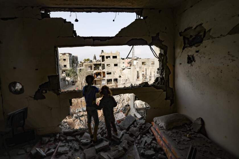 TOPSHOT - Palestinian children who have returned to their neighbourhood, stare at the damaged from their home, hit by Israeli bombardment in Gaza City, after a ceasefire brokered by Egypt between Israel and Hamas, on May 21, 2021. - A ceasefire between Israel and Hamas, the Islamist movement which controls the Gaza Strip, appeared to hold today after 11 days of deadly fighting that pounded the Palestinian enclave and forced countless Israelis to seek shelter from rockets. (Photo by MOHAMMED ABED / AFP) (Photo by MOHAMMED ABED/AFP via Getty Images)