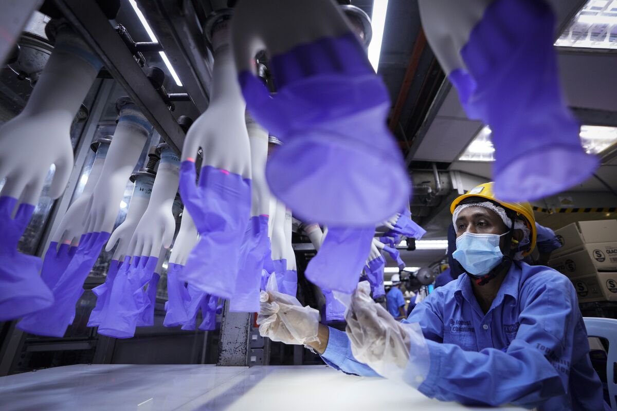 A worker inspects disposable gloves at the Top Glove factory on the outskirts of Kuala Lumpur, Malaysia.