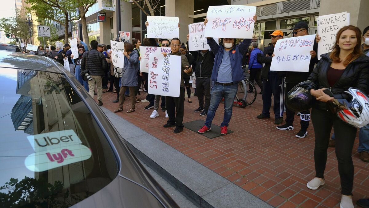 Uber and Lyft drivers demonstrate outside of Uber headquarters in San Francisco on May 8.