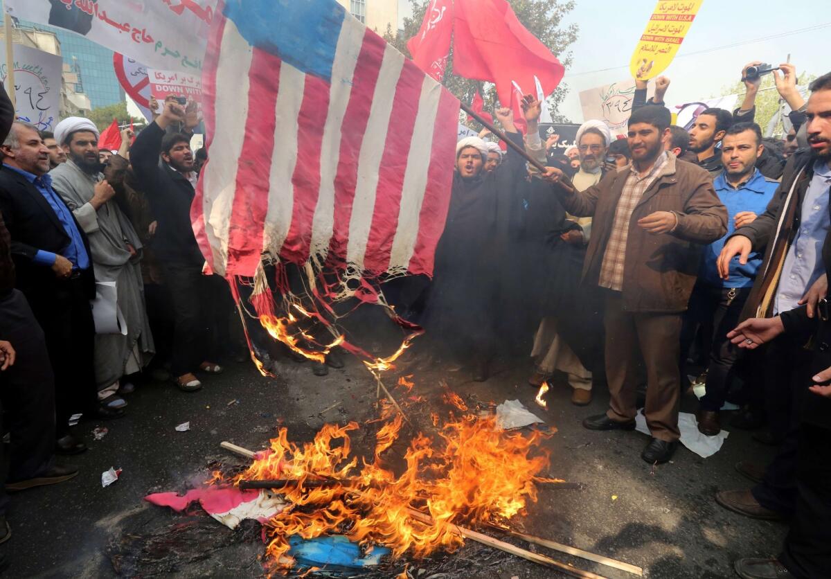 Iranians burn an American flag outside the former U.S. Embassy in Tehran on Nov. 4, 2015, during a rally marking the anniversary of its storming by student protesters that triggered a hostage crisis in 1979.