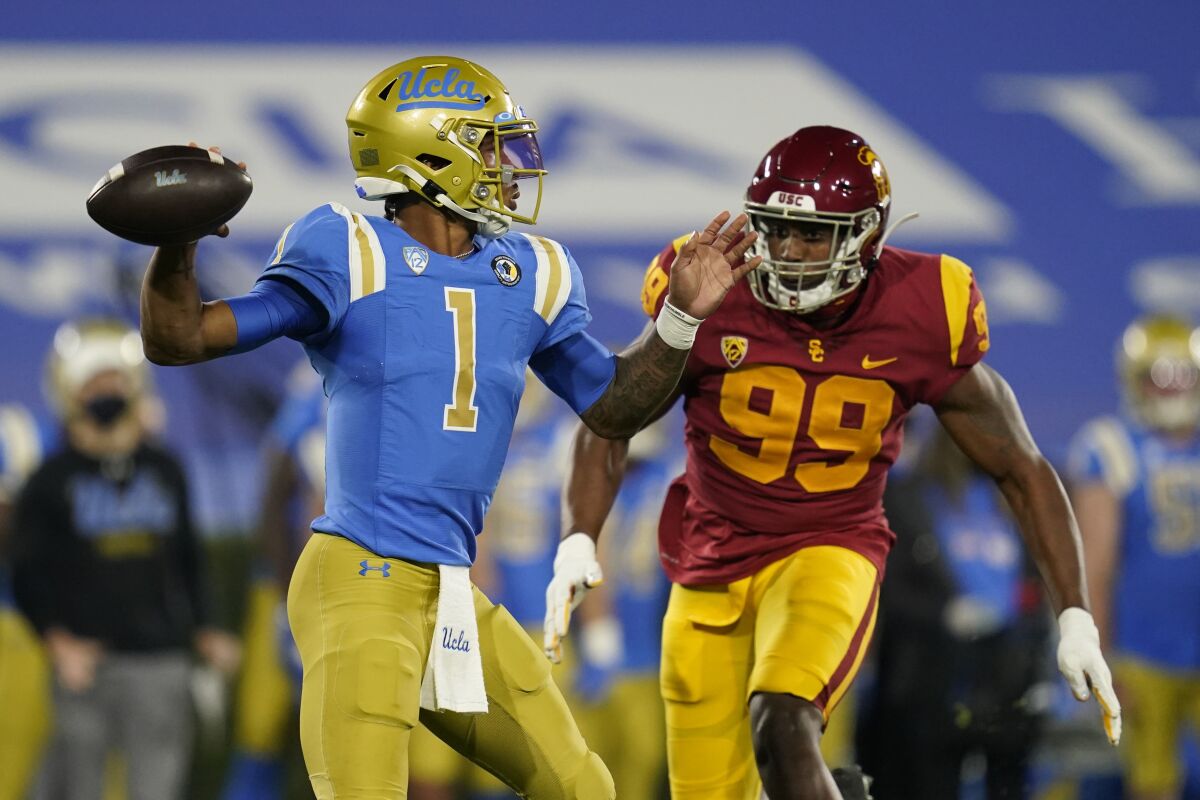 UCLA quarterback Dorian Thompson-Robinson is threatened by USC linebacker Drake Jackson.