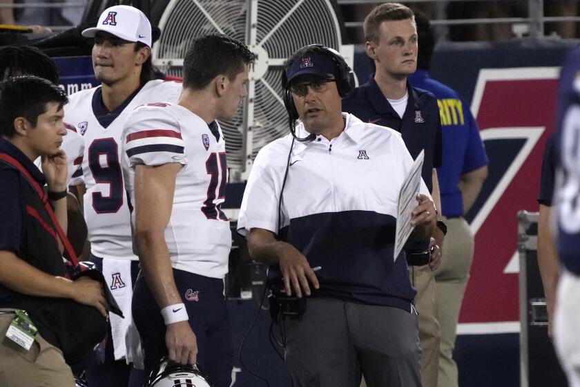 Arizona head coach Jedd Fisch talks to quarterback Will Plummer (15) in the first half during an NCAA college football game against Northern Arizona, Saturday, Sept. 18, 2021, in Tucson, Ariz. (AP Photo/Rick Scuteri)