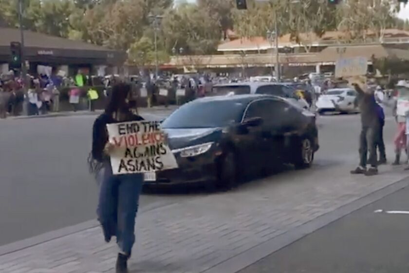 A frame grab from a Instagram video of a rally against anti-Asian hate in Diamond Bar Sunday shows a car driving through a group of protestors while yelling at them, triggering a law enforcement investigation.