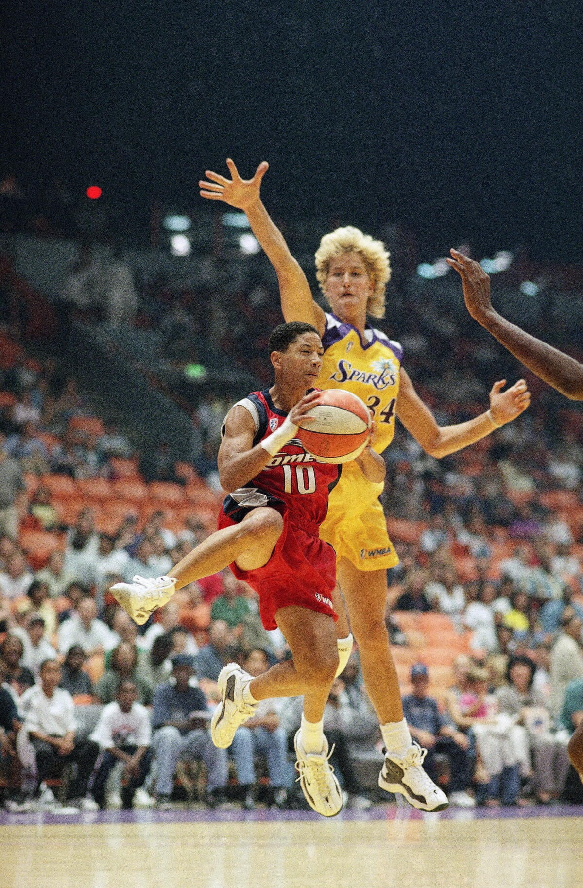 Heidi Burge, right, rises up to artifact Houston Comets defender Kim Perrot during a crippled connected July 16, 1997.