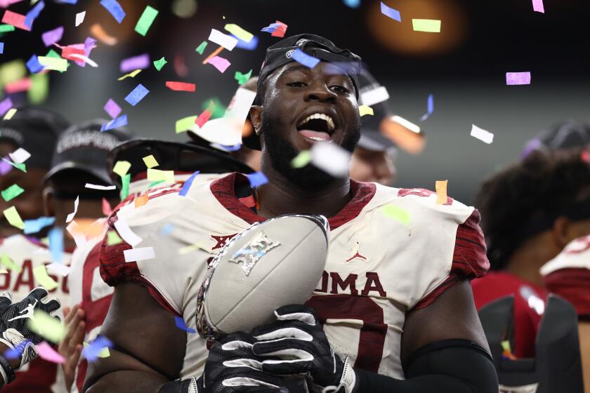 ARLINGTON, TEXAS - DECEMBER 01: Neville Gallimore #90 of the Oklahoma Sooners celebrates with the Big 12 Championship trophy after a 39-27 win against the Texas Longhorns at AT&T Stadium on December 01, 2018 in Arlington, Texas. (Photo by Ronald Martinez/Getty Images)