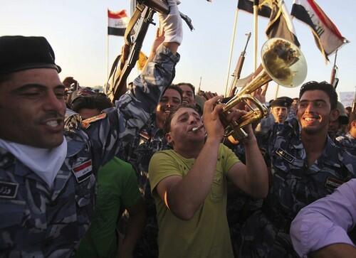 Iraqi security troops in the western city of Ramadi, the capital of Anbar province, celebrate taking over from withdrawing U.S. troops. There were no dramatic last-minute scenes of the American military pulling out of urban bases to meet Tuesday?s deadline.