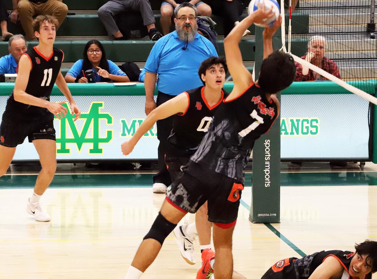 Huntington Beach's Kai Gan (7) sets the ball, as Logan Hutnick (11) and Kaegan Ramdhani (0) look on against Mira Costa.