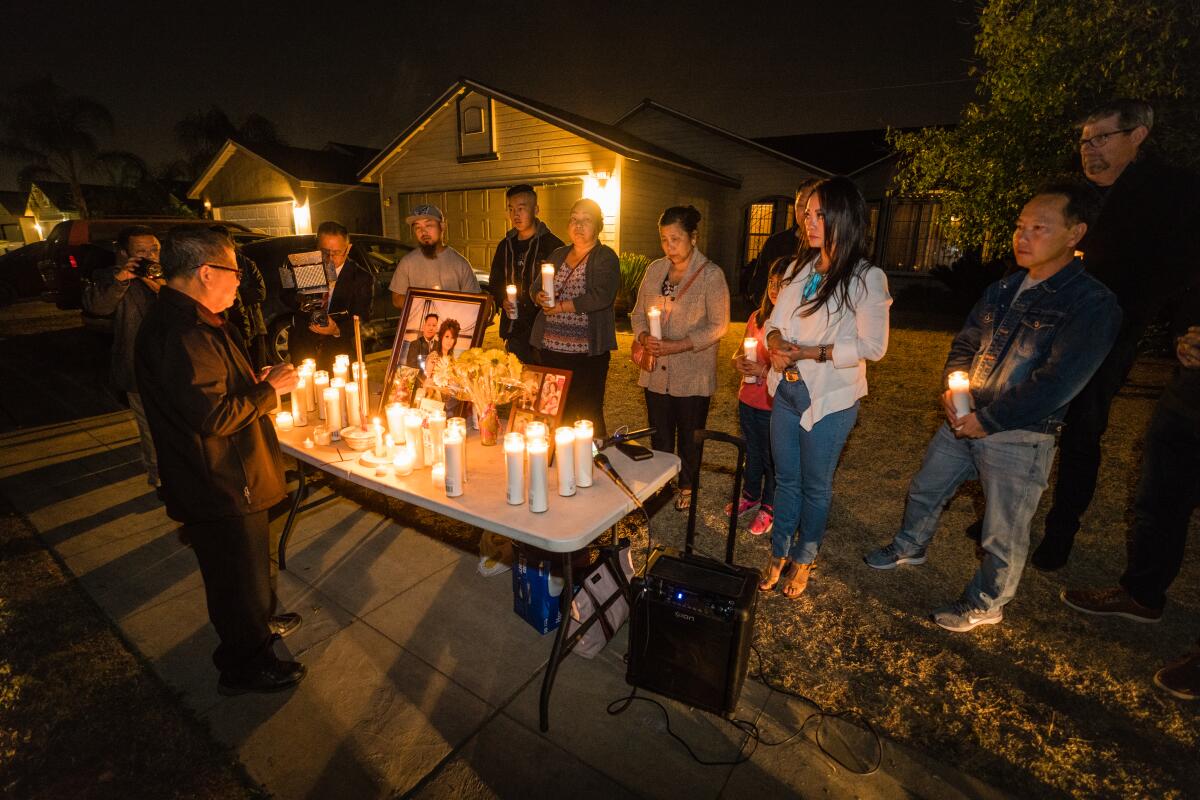 Family members gathered for a candlelight vigil for four men who were shot killed in the backyard of this residence on Sunday, during a family party while watching a football game. Hmong community advocate Paula Yang led the service on behalf of the family of two of the deceased.