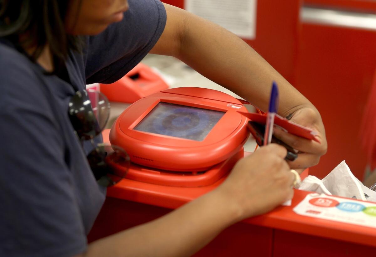 State legislators at a hearing Tuesday delved into the causes of a recent hacking of about 70 million computerized customer records at Target and a smaller incident involving about 1.1 million customers at Neiman Marcus department stores. Above, a Target customer at a store checkout.