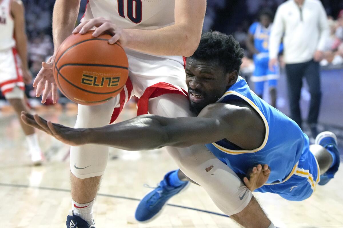 UCLA center Adem Bona dives for the ball behind Arizona forward Azuolas Tubelis during the second half.